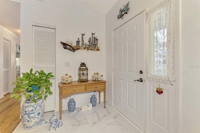 entryway with baseboards and marble finish floor