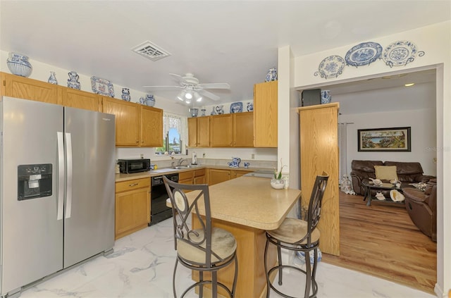 kitchen with visible vents, black dishwasher, a peninsula, stainless steel fridge, and a sink