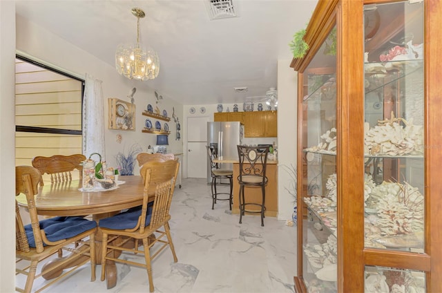 dining space featuring visible vents, marble finish floor, and an inviting chandelier