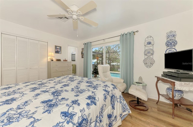 bedroom featuring visible vents, baseboards, wood finished floors, a closet, and a ceiling fan