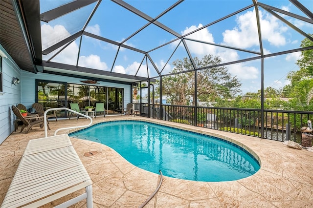 view of pool featuring a patio area, a fenced in pool, and glass enclosure