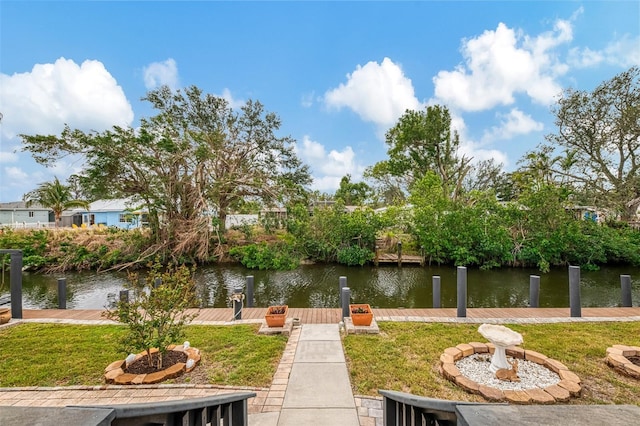 surrounding community featuring a yard, a water view, and a boat dock