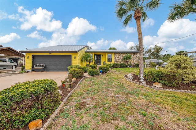 ranch-style home with a garage, a front lawn, driveway, and metal roof