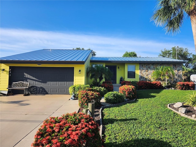 1173 Brown St, Englewood, FL 34224 - view of front of property featuring a garage, a standing seam roof, concrete driveway, and a front lawn