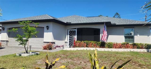 view of front of property featuring a garage, a shingled roof, a front lawn, and stucco siding