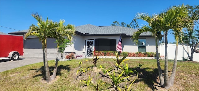 view of front of home with a front yard, an attached garage, driveway, and stucco siding