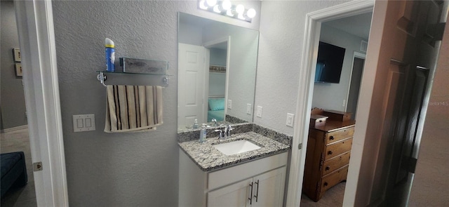 bathroom featuring vanity and a textured wall