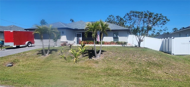 ranch-style home with a front lawn, fence, and stucco siding