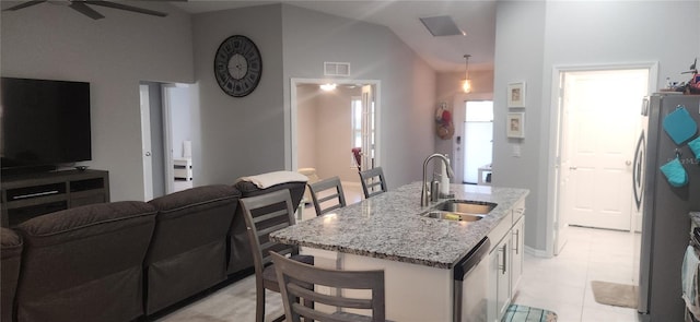 kitchen featuring vaulted ceiling, open floor plan, appliances with stainless steel finishes, and a sink