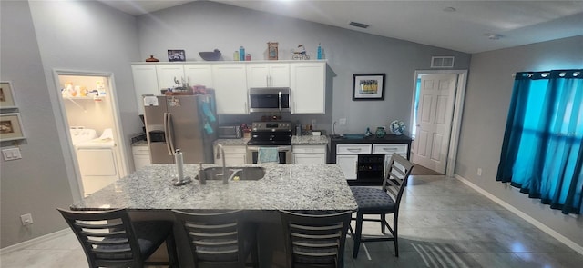 kitchen featuring washer and clothes dryer, visible vents, appliances with stainless steel finishes, and a sink