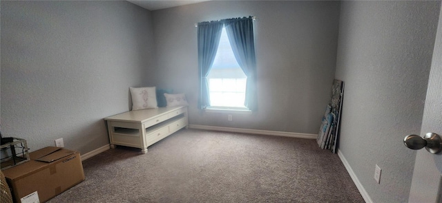 carpeted bedroom with baseboards and a textured wall