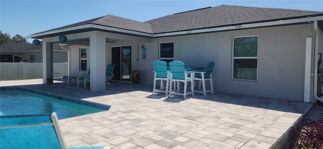 back of house featuring a fenced in pool, fence, roof with shingles, and a patio area