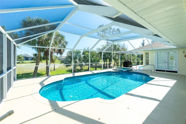 view of pool with glass enclosure, a patio, and a pool with connected hot tub