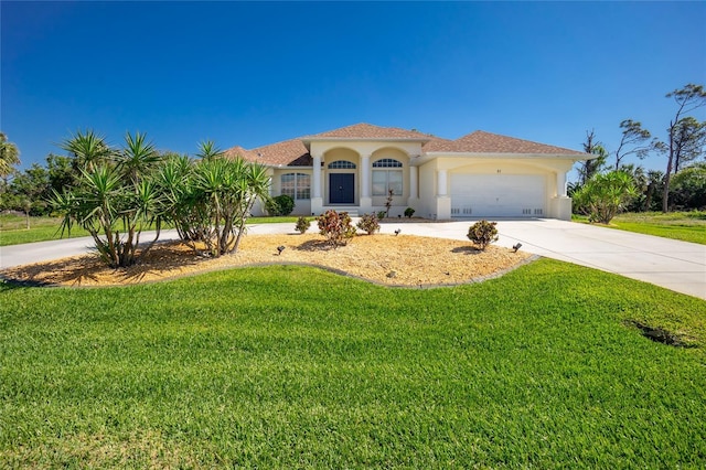 mediterranean / spanish-style home featuring a front lawn, an attached garage, driveway, and stucco siding