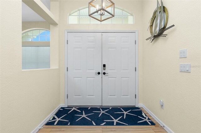 entryway with a chandelier, baseboards, and a wealth of natural light