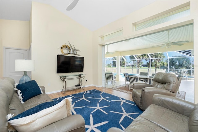 living room featuring lofted ceiling, wood finished floors, a sunroom, baseboards, and ceiling fan