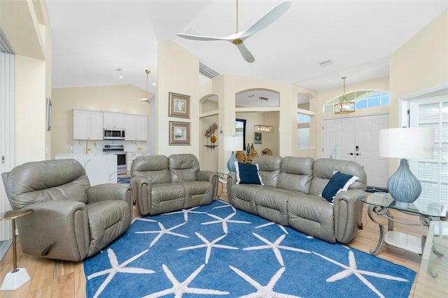 living room with high vaulted ceiling, visible vents, light wood finished floors, and ceiling fan