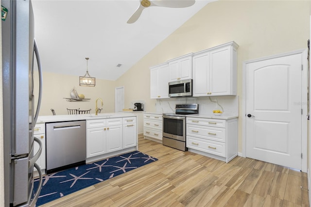 kitchen featuring light wood-style flooring, a sink, appliances with stainless steel finishes, white cabinets, and light countertops