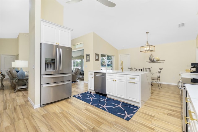 kitchen featuring visible vents, white cabinets, stainless steel appliances, and light wood-type flooring