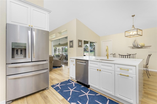 kitchen with light wood-style flooring, a sink, light countertops, white cabinets, and appliances with stainless steel finishes