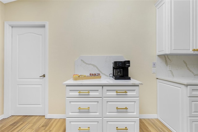 interior details featuring decorative backsplash, baseboards, and wood finished floors