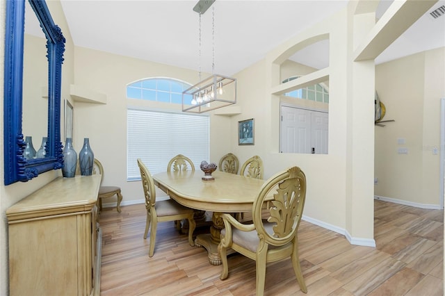 dining room featuring visible vents, baseboards, and light wood finished floors