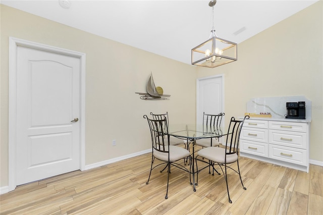 dining area with an inviting chandelier, baseboards, and light wood finished floors