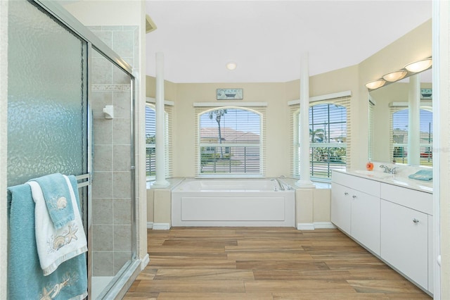 full bath featuring vanity, wood finished floors, a shower stall, and a bath