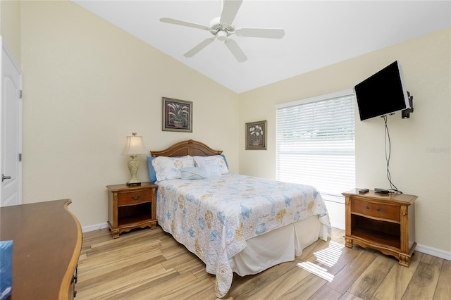 bedroom with baseboards, lofted ceiling, light wood-style flooring, and a ceiling fan