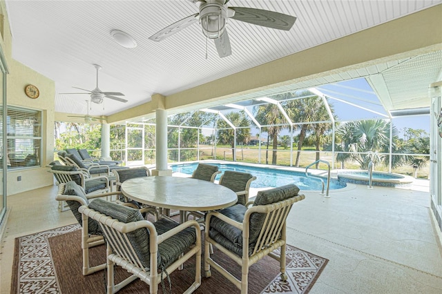 exterior space featuring glass enclosure, a pool with connected hot tub, ceiling fan, and a patio area