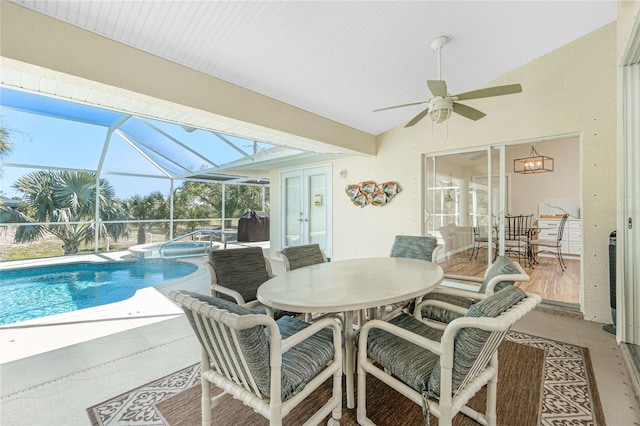 exterior space with a pool with connected hot tub, ceiling fan, outdoor dining area, a lanai, and a patio area