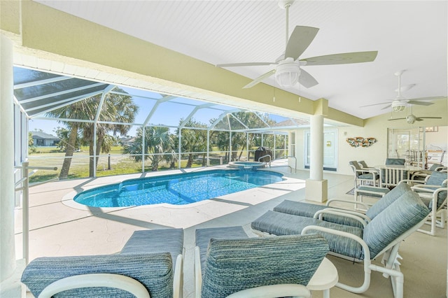 view of swimming pool featuring a ceiling fan, a pool with connected hot tub, a patio, glass enclosure, and an outdoor hangout area