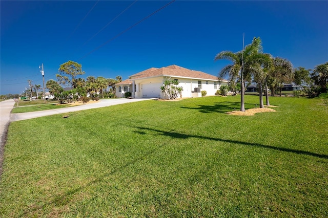 view of front facade with an attached garage, concrete driveway, and a front lawn