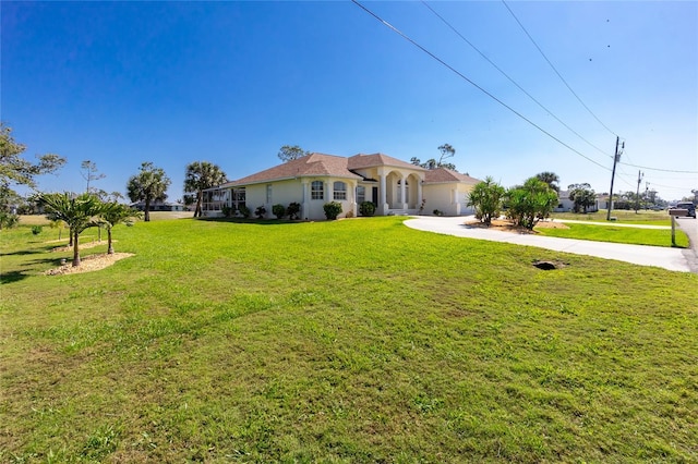 view of front of home featuring stucco siding, driveway, a front lawn, and a garage