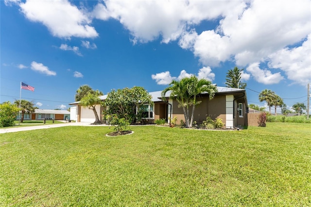 view of front facade featuring stucco siding, a front lawn, a garage, and driveway