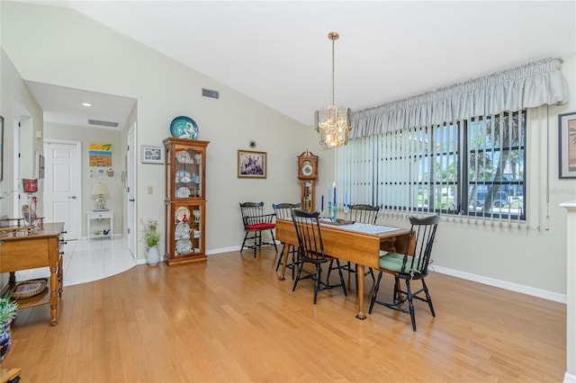 dining area with an inviting chandelier, light wood-style flooring, baseboards, and visible vents