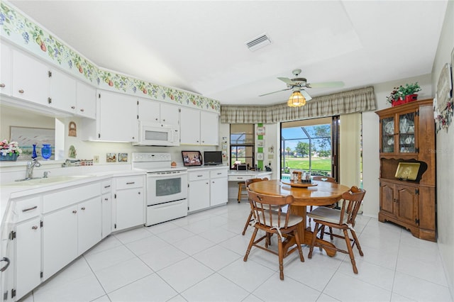 kitchen with white appliances, visible vents, a sink, light countertops, and white cabinets