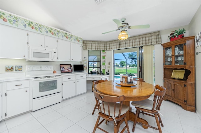 kitchen with light tile patterned floors, white appliances, white cabinetry, and light countertops