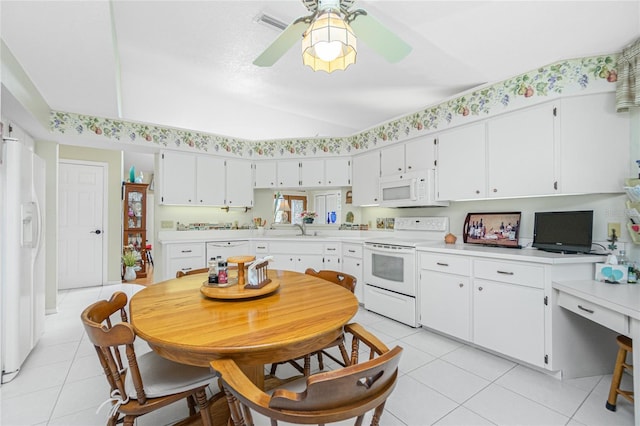 kitchen with a sink, white appliances, light tile patterned flooring, and light countertops