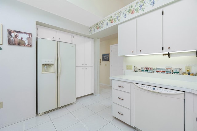 kitchen with light tile patterned floors, white appliances, white cabinetry, and light countertops