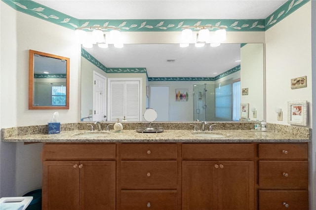 full bathroom with a shower stall, double vanity, and a sink