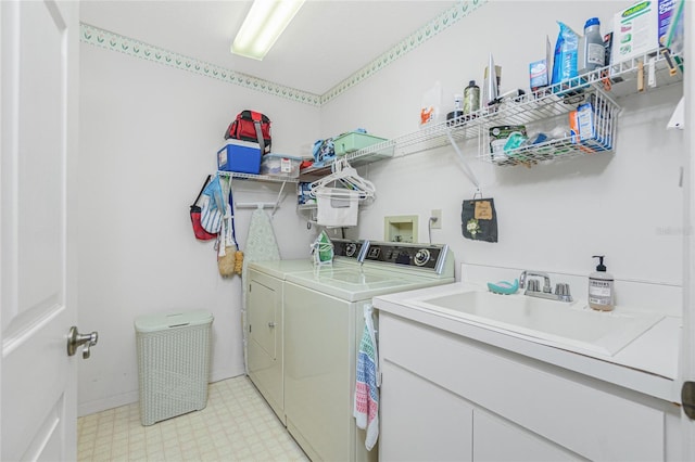 laundry area with a sink, light floors, laundry area, and washing machine and clothes dryer