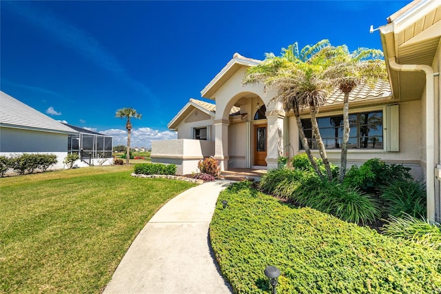 exterior space featuring a tile roof, a lawn, and stucco siding