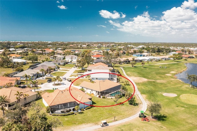 drone / aerial view with a residential view, golf course view, and a water view