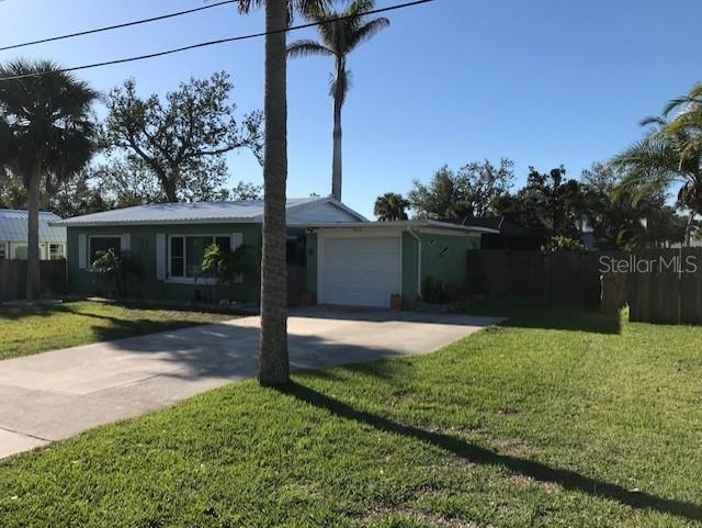 ranch-style house featuring concrete driveway, an attached garage, fence, and a front yard