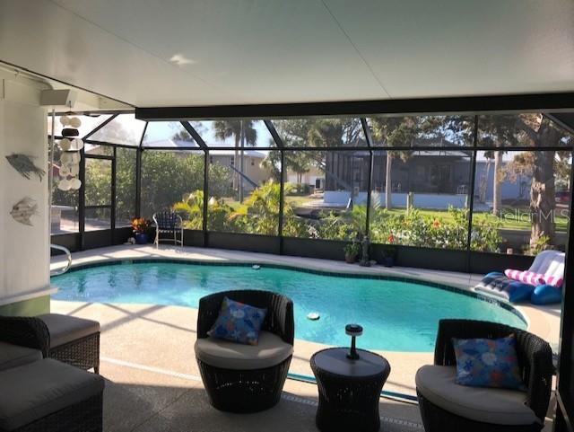 pool with glass enclosure and a patio