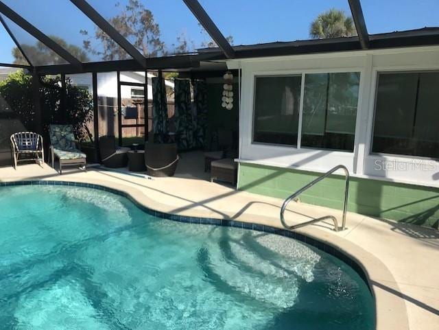 pool with a lanai, outdoor lounge area, and a patio area