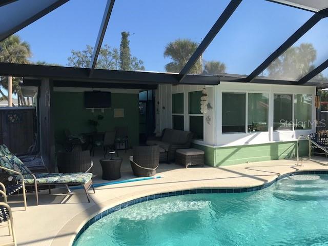 outdoor pool featuring a patio, a lanai, and an outdoor hangout area