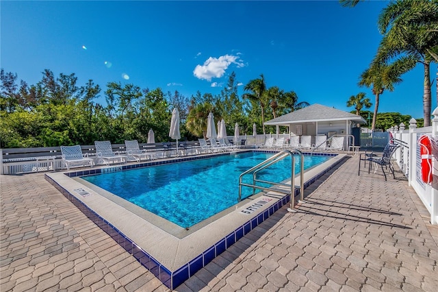 pool with a patio area and fence