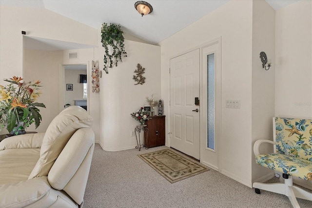 foyer featuring baseboards, lofted ceiling, carpet floors, and visible vents